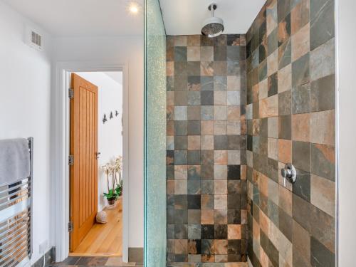 Cullercoats鹅卵石小屋的一间带淋浴的浴室和瓷砖墙