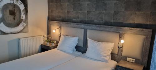 Elsendorp凯哲斯堡餐厅酒店的一间卧室配有带白色床单和枕头的床。