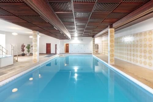 斯特兰拉尔西北城堡酒店的大楼内的一个蓝色海水游泳池