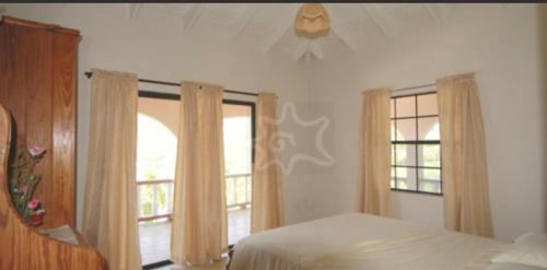 Port ElizabethThe View Villa的一间卧室设有一张床和两个窗户。