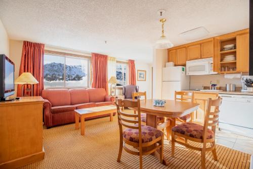 六月湖海德堡度假酒店的厨房以及带桌椅的起居室。