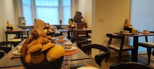 德帕内B&B Charles Cabour的配有桌椅和一篮面包的餐厅