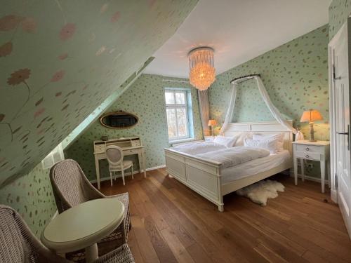 朗克维茨Peeneblick - Traumhaus direkt am Wasser mit eigenem Bootssteg für 8 Personen的卧室配有一张床和一张桌子及椅子