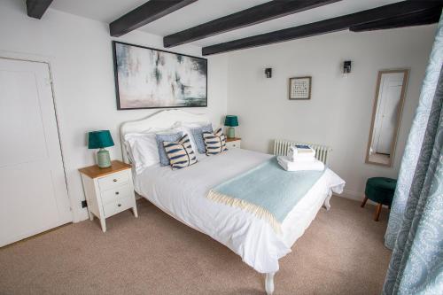 惠特比Whitby Boutique - Mast Cottage的卧室配有带蓝色枕头的大型白色床