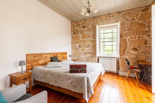 卡拉穆卢Casa do Cabeço的一间卧室设有一张床和石墙