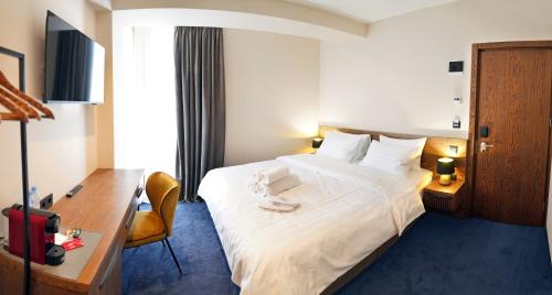 第比利斯Hotel Tiflisi Inn的酒店客房设有一张大床和一张书桌。