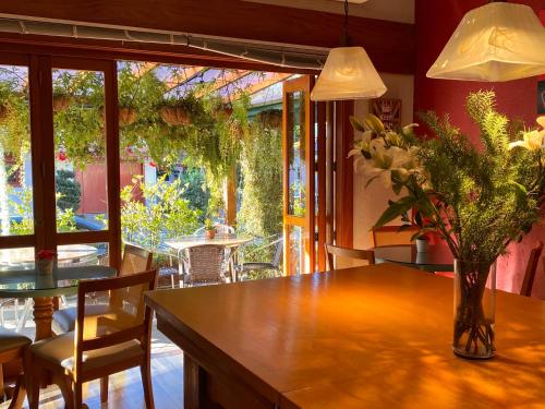 格拉玛多Hotel Britanico Express的用餐室,配有一张桌子和花瓶