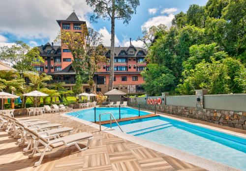 格拉玛多西拉角酒店的一个带躺椅的游泳池,以及一间位于酒店后面的酒店