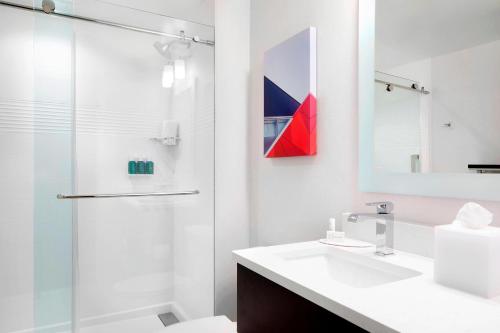 哥伦布TownePlace Suites by Marriott Columbus Easton Area的白色的浴室设有水槽和淋浴。