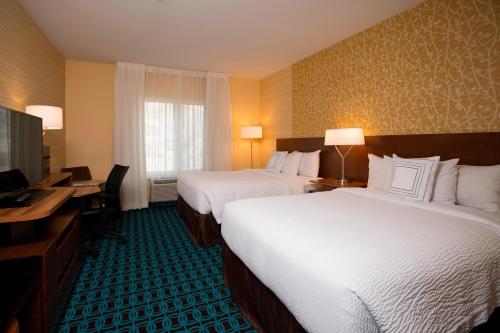 杜兰戈普林斯顿万豪费尔菲尔德套房酒店 的酒店客房设有两张床、一张桌子和一台电视。