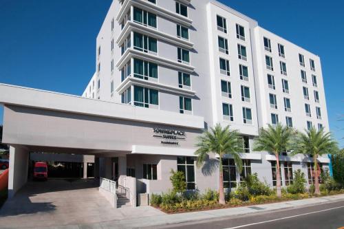 迈阿密迈阿密机场万豪广场套房酒店 的一座白色的建筑,前面有棕榈树