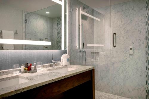 格林斯伯勒格林斯博罗高点机场万豪酒店的一间带水槽和玻璃淋浴的浴室