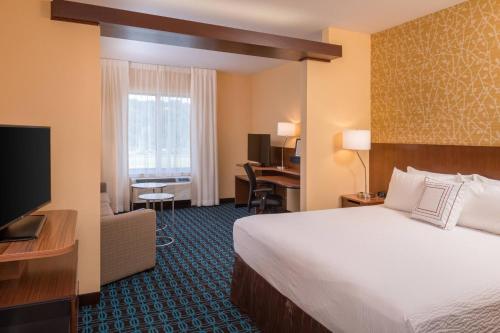 亨廷顿Fairfield Inn & Suites by Marriott Huntington的酒店客房,配有床和电视