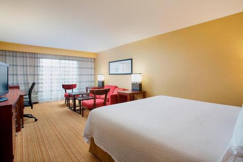 贝德福德公园芝加哥中途机场万怡酒店的酒店客房带一张床、一张桌子和椅子