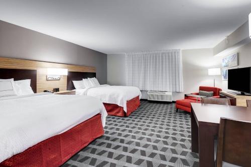 奥斯汀TownePlace Suites by Marriott Austin Parmer/Tech Ridge的酒店客房设有两张床和一台平面电视。
