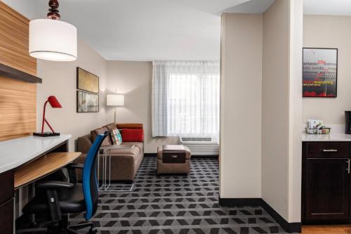 普莱诺TownePlace Suites by Marriott Dallas Plano/Legacy的酒店客房配有书桌和沙发。