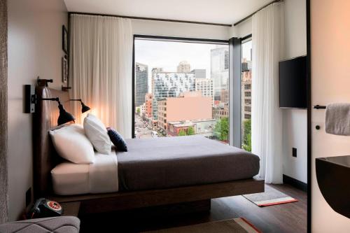 芝加哥Moxy Chicago Downtown的一间卧室设有一张床和一个大窗户