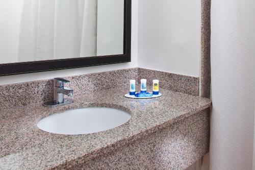 休斯顿休斯敦霍比机场费尔菲尔德套房酒店 的浴室水槽配有2个牙刷和镜子