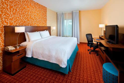 休斯顿休斯敦霍比机场费尔菲尔德套房酒店 的酒店客房配有一张床、一张书桌和一台电视。