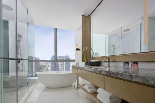 包头包头茂业万豪酒店的一间带浴缸和大镜子的浴室