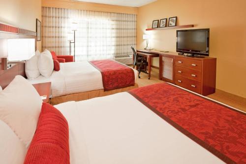 兀兰休斯顿庭院伍德兰酒店的酒店客房设有两张床和一台平面电视。