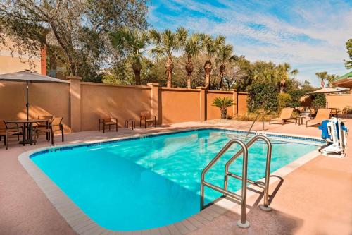 盖恩斯维尔Courtyard by Marriott Gainesville FL的度假酒店内带桌椅的游泳池