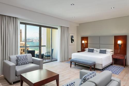 迪拜朱美拉海滩华美达广场酒店的一间卧室设有一张床和一间客厅。