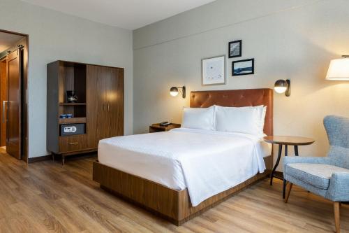 蒙特雷Four Points by Sheraton Monterrey Airport的配有一张床和一把椅子的酒店客房
