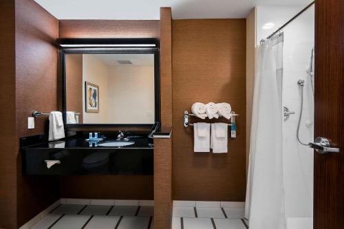 本顿小石城顿万豪费尔菲尔德套房酒店的浴室配有盥洗盆和带镜子的淋浴