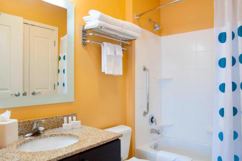 约翰斯顿到恩普拉斯套房酒店德梅因厄本代尔的浴室配有盥洗盆、卫生间和浴缸。
