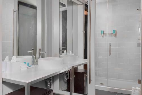 盖恩斯维尔Aloft Gainesville University Area的白色的浴室设有2个盥洗盆和淋浴。