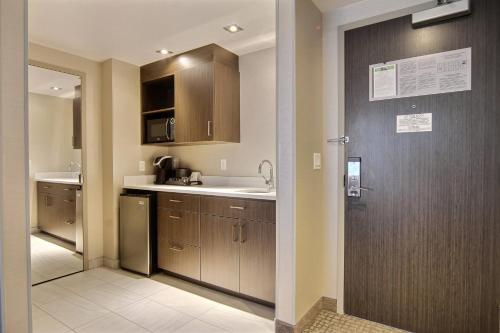 魁北克市魁北克万怡酒店的厨房配有木制橱柜、水槽和门