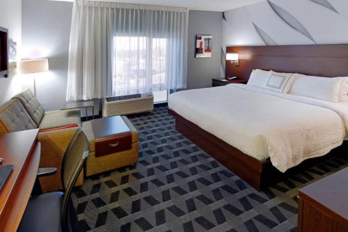 斯普林菲尔德斯普林菲尔德唐普雷斯万豪广场套房酒店的酒店客房设有一张大床和一张书桌。