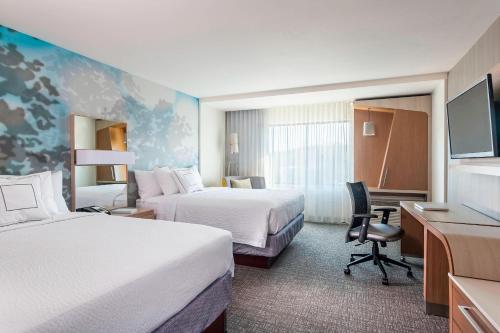 苏城Courtyard Sioux City Downtown/Convention Center的酒店客房配有两张床和一张书桌