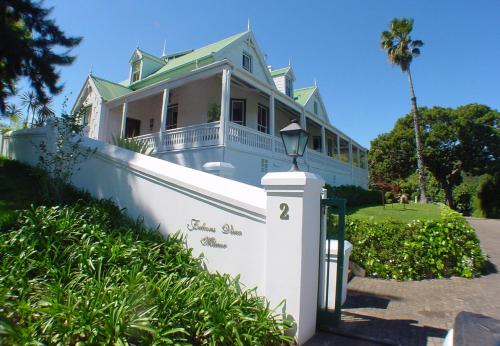 克尼斯纳猎鹰视角庄园酒店的白色的房子,有绿色的屋顶和栅栏