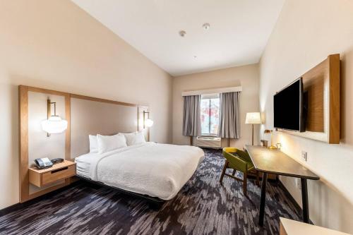 盖恩斯维尔Fairfield Inn & Suites by Marriott Gainesville I-35的酒店客房配有一张床、一张书桌和一台电视。