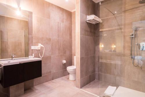 哈博罗内Protea Hotel by Marriott Gaborone Masa Square的浴室配有卫生间、盥洗盆和淋浴。