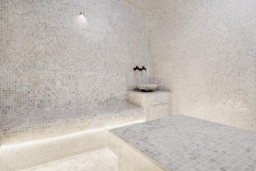 迪拜Courtyard by Marriott World Trade Centre, Dubai的白色的浴室设有浴缸和水槽。
