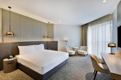 迪拜Courtyard by Marriott Dubai, Al Barsha的配有一张床和一张书桌的酒店客房