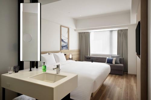 大阪Fairfield by Marriott Osaka Namba的酒店客房设有白色的床和水槽