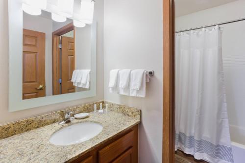 圣路易斯帕克西明尼阿波利斯/圣路易斯公园万豪广场套房酒店的一间带水槽、镜子和淋浴的浴室