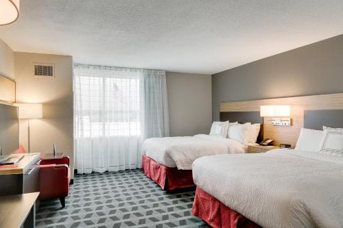 利伯蒂TownePlace Suites by Marriott Kansas City Liberty的酒店客房设有两张床和窗户。