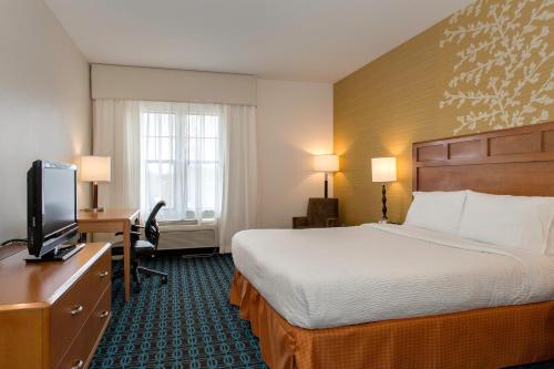 塞瓦斯托波尔圣罗莎塞瓦斯托波尔费尔菲尔德客栈套房酒店的配有一张床和一台平面电视的酒店客房