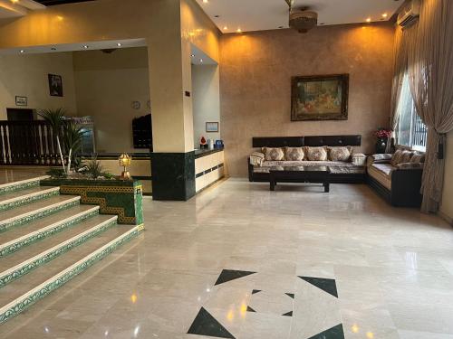 马拉喀什Hotel Majorelle的大楼内一个带沙发和楼梯的大堂