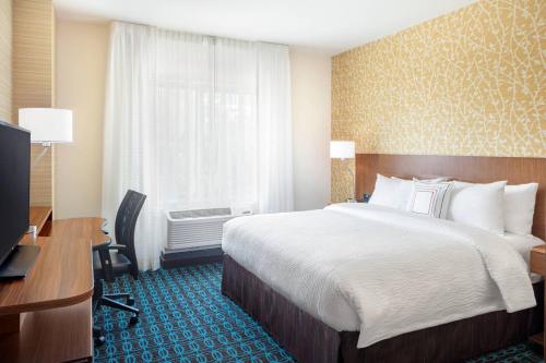 北卑尔根北卑尔根万豪费尔菲尔德套房酒店的配有一张床、一张书桌和一扇窗户的酒店客房