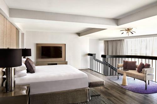 旧金山旧金山马奎斯联合广场万豪酒店的一间卧室配有一张床、一台电视和一张沙发