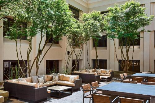 旧金山旧金山马奎斯联合广场万豪酒店的酒店大堂设有长沙发、桌子和树木