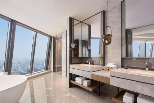 金华金华万豪酒店的浴室设有2个水槽、浴缸和镜子