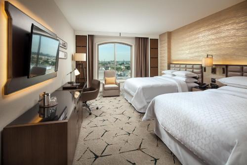 圣盖博洛杉矶圣加百利喜来登酒店的酒店客房设有两张床和一台平面电视。