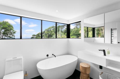 库鲁姆海滩巴比隆库拉姆公寓的白色的浴室设有大浴缸和窗户。